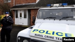 FILE - A police officer stands guard outside of the home of former Russian military intelligence officer Sergei Skripal, in Salisbury, Britain, March 6, 2018.