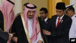 Presiden Joko Widodo membantu Raja Salman berjalan dalam pertemuan mereka di Istana Bogor (1/3). (AP/Achmad Ibrahim)