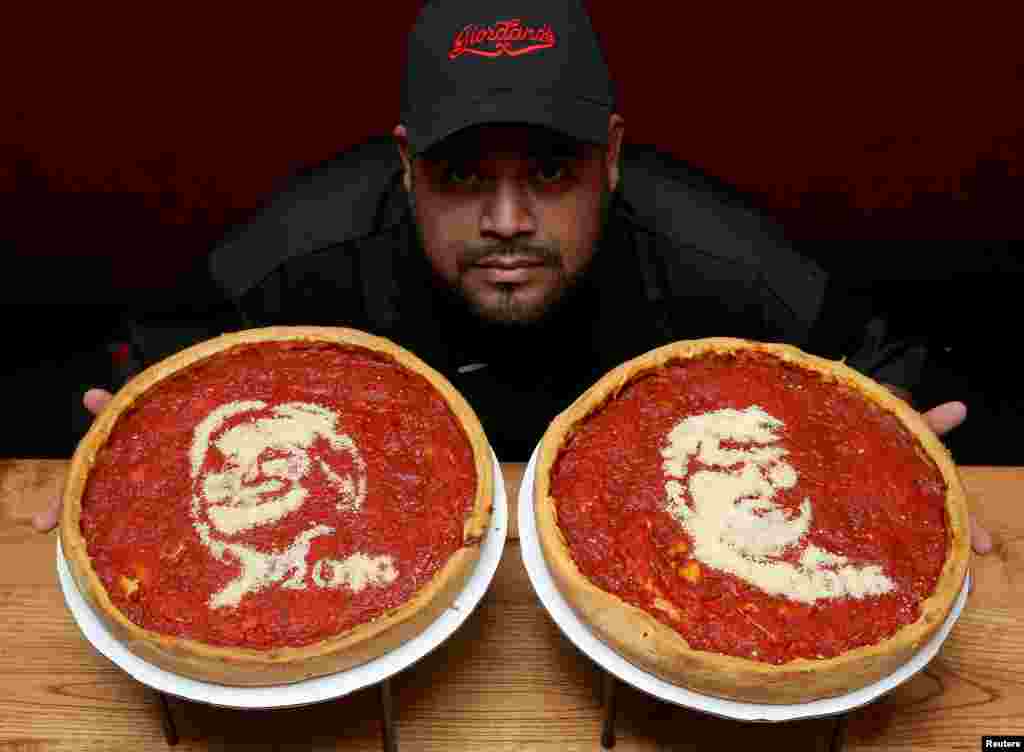Head cook Fabian Martinez poses with pizza's decorated with the images of U.S. Democratic presidential nominee Hillary Clinton (L) and Republican presidential nominee Donald Trump at Giordano's Pizzeria in Chicago, Ilinois, Sept. 27, 2016.