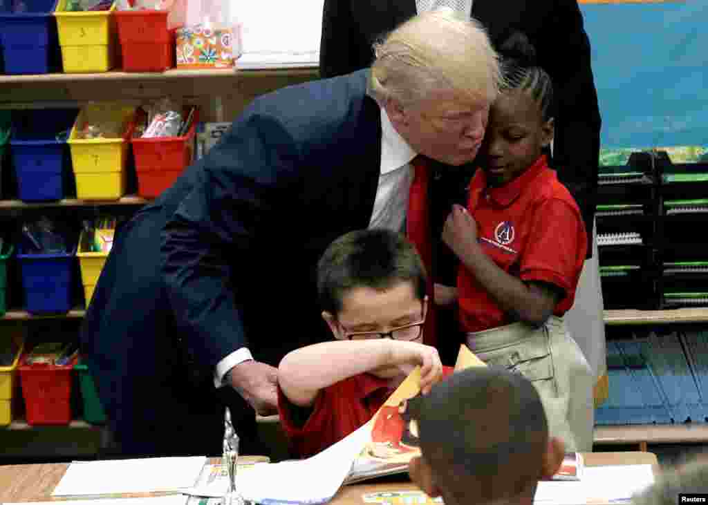 Republican presidential nominee Donald Trump hugs a student after receiving a bible as a gift during a campaign visit to the International Church of Las Vegas and the International Christian Academy in Las Vegas, Nevada, Oct. 5, 2016.