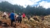 Orang-orang melintasi area longsor untuk sampai ke sisi lain di desa Yambali, Papua Nugini, Jumat, 24 Mei 2024. Lebih dari 100 orang diyakini tewas dalam bencana tanah longsor di negara kepulauan Pasifik Selatan itu. (Benjamin Sipa/Organisasi Internasional untuk Migrasi via AP)