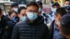 Pemimpin redaksi Stand News Patrick Lam dibawa menuju kantor media tersebut dengan tangan terborgol setelah polisi menggerebek media tersebut pada 29 Desember 2021. (Foto: AFP/Daniel Suen)