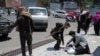 A Taliban fighter searches the belongings of a pedestrian along a blocked street ahead of a council meeting of tribal and religious leaders in Kabul, June 29, 2022.