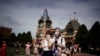Sejumlah pengunjung Shanghai Disney Resort tampak mengenakan masker ketika berkunjung ke taman hiburan tersebut pada 30 Juni 2022. Taman hiburan itu mulai dibuka kembali untuk pengunjung setelah ditutup akibat penyebaran COVID-19 di Shanghai, China. (Foto: Reuters/Aly Song)