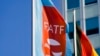 A flag with the logo of the Financial Action Task Force (FATF) waves in the wind next to the German national flag during a meeting of the group at the Congress Center in Berlin, June 17, 2022.