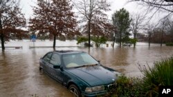 Sebuah mobil terendam air banjir di Camden, pinggiran Sydney, Australia, Senin, 4 Juli 2022. (Foto: Ilustrasi/AP)