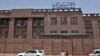 FILE - Afghan men walk past Da Afghanistan Bank in Kabul on June 28, 2011. 