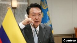 윤석열 한국 대통령이 지난 6월 집무실에 콜롬비아 국기를 놓고 이반 두케 콜롬비아 대통령과 통화하고 있다. (자료사진)