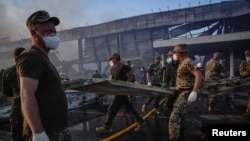 Spasilačke ekipe na mestu napada u Kremenčuku (Foto: REUTERS/Anna Voitenko)