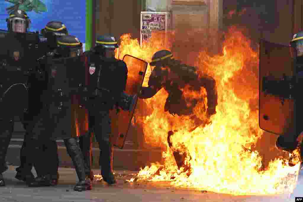 A French riot police officer is surrounded by flames, during a demonstration against the controversial labor reforms of the French government in Paris. Opponents of France's controversial labor reforms took to the streets for the 14th time in six months in a last-ditch bid to quash the measures that lost the Socialist government crucial support on the left.