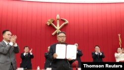 북한 김정은 국무위원장이 17일 평양에서 열린 노동당 중앙위원회 제8기 제3차 전원회의 3일차 회의에서 자신이 서명한 문서를 들어보이고 있다.