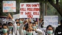 Para siswa mengacungkan poster-poster berisi slogan-slogan memprotes mengenai tingkat polusi di New Delhi, India, 15 November 2017.