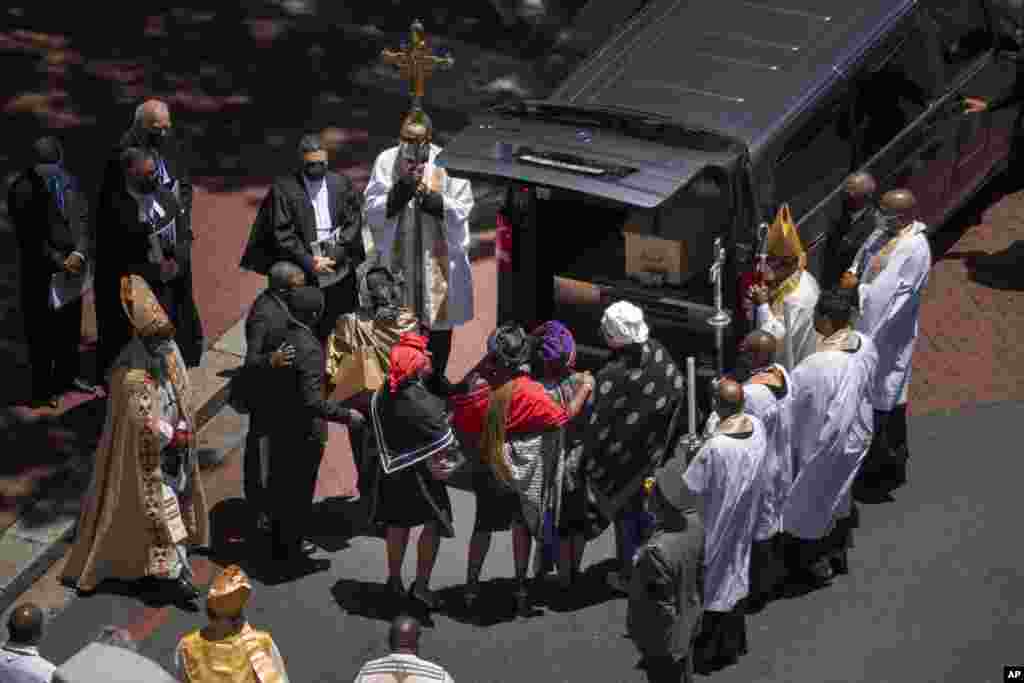 Relatives hug in front of the casket carrying the remains of Anglican Archbishop Emeritus Desmond Tutu after it was put in a hearse following his funeral service at the St. George's Cathedral in Cape Town, South Africa, Jan.1, 2022.
