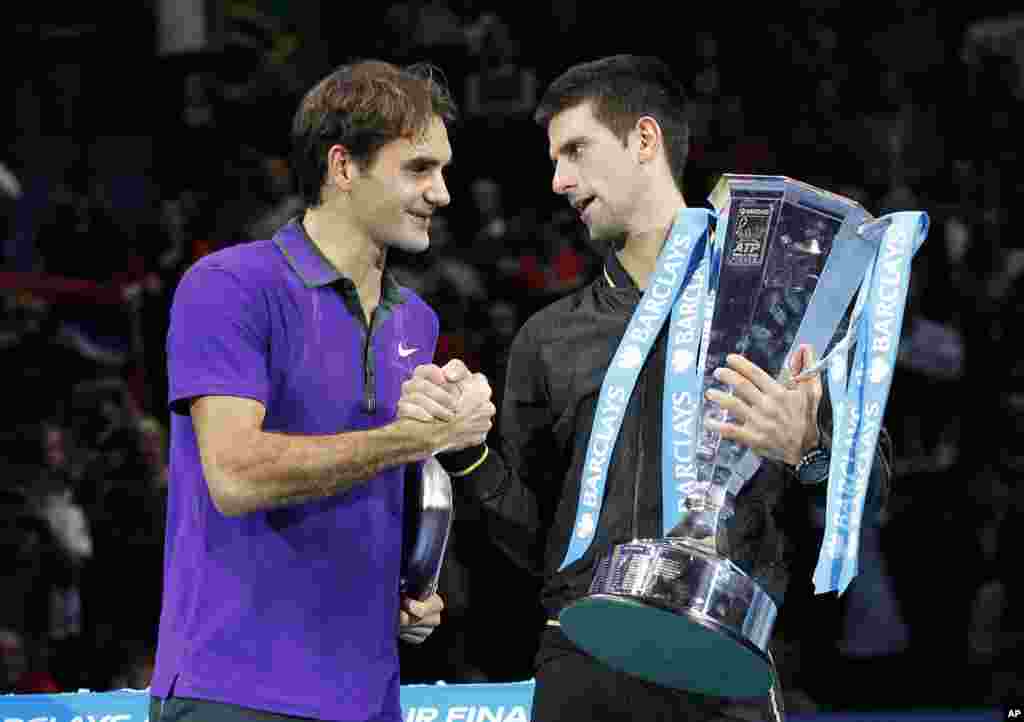 Iskrena čestitka: Stisak ruke Federera i Đokovića tokom poziranja fotoreporterima (AP Photo/Sang Tan)