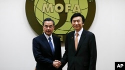 왕이 중국 외교부장(왼쪽)이 26일 한-중 외교장관 회담을 위해 외교부 청사를 방문, 회담에 앞서 윤병세 외교부 장관과 악수하고 있다. (자료사진)