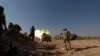 FILE - Free Syrian Army fighters fire from a tank during offensive to take control of al-Zaalana checkpoint in Wadi al-Deif military camp, southern Idlib countryside, July 9, 2014.