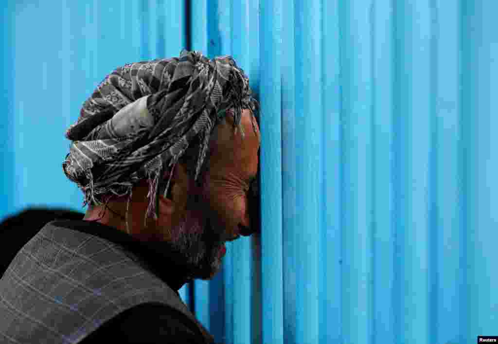 An Afghan mourns at the gate of the Sakhi Shrine after an overnight attack in Kabul, Afghanistan, Oct.12, 2016.