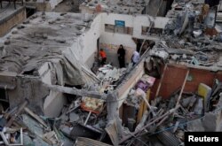 Warga Palestina memeriksa kerusakan di lokasi serangan Israel terhadap rumah-rumah, di tengah konflik yang sedang berlangsung antara Israel dan kelompok Islam Palestina Hamas, di Khan Younis di selatan Jalur Gaza, 29 Oktober 2023. (Foto: REUTERS/Mohammed Salem)
