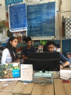 Customers use their phones to make digital payments at the local shop. (A. Pasricha/VOA)