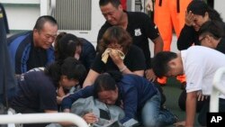 Family members cry around the body of Taiwanese fisherman Hung Shih-cheng after his boat, the Kuang Ta Hsing No. 28, arrived at Liuqiu port in Pingtung County, southern Taiwan, May 11, 2013. 