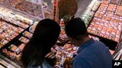 Pelanggan tampak memilah produk laut yang diimpor dari Jepang di sebuah supermarket di Hong Kong, pada 12 Juli 2023. (Foto: AP/Louise Delmotte)
