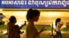 Sejumlah orang berjalan sambil menggunakan ponsel mereka di Phnom Penh, Kamboja, 18 Februari 2021. (Foto: Reuters)