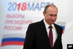 Russian President Vladimir Putin arrives to vote at a polling station during Russia's presidential election in Moscow, Russia, March 18, 2018.
