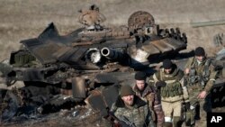 Сепаратисти оглядають знищений українських танк.