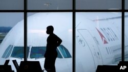 미국 애틀랜타 하츠필드 잭슨 국제공항 이용객이 마스크를 쓴 채 계류장을 바라보고 있다. (자료사진)