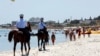 FILE - Mounted police officers patrol on the beach of Sousse, Tunisia, June 28, 2015. 