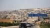 FILE - A journalists' convoy is seen at the entrance of Khan Sheikhoun, Idlib, Syria, Aug. 24, 2019.