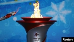 20일 베이징에 도착한 2022 동계올림픽 성화가 환영식 현장에 설치된 성화대로 옮겨지고 있다.