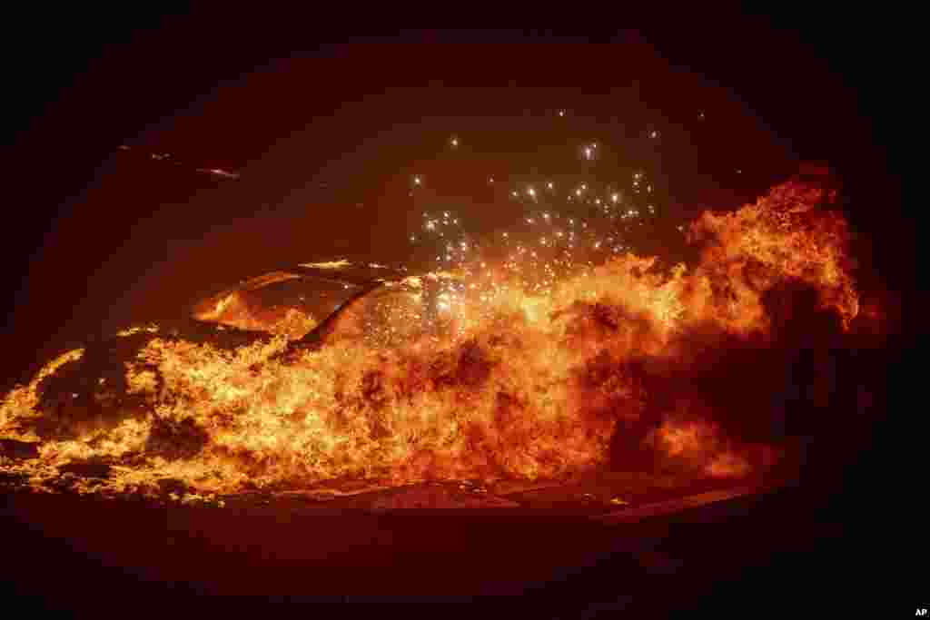 A vehicle burns as the Palisades Fire advances in the Pacific Palisades neighborhood of Los Angeles, Jan. 7, 2025.