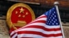 FILE - An American flag is flown next to the Chinese national emblem during a welcome ceremony for visiting U.S. President Donald Trump outside the Great Hall of the People in Beijing, Nov. 9, 2017.
