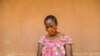 FILE - A woman checks her phone in Yaounde, Cameroon, April 23, 2020. 