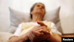 FILE - Alzheimer's disease patient Isidora Tomaz, 82, sits in an armchair in her house in Lisbon, Portugal.