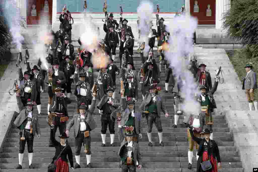 Bavarian riflemen and women in traditional costumes fire their muzzle loaders in front of the 'Bavaria' statue on the last day at the 183rd Oktoberfest beer festival in Munich, southern Germany, Oct. 3, 2016..