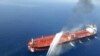 FILE - An Iranian navy boat sprays water to extinguish a fire on an oil tanker in the Gulf of Oman, June 13, 2019.