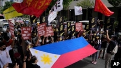 Protesters shout slogans as they hold a Philippine flag during a rally in front of the Chinese Consulate in Makati city, Philippines on Monday, July 12, 2021. The demonstration was held to commemorate the 5th anniversary of the Arbitral Ruling in…