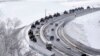 A convoy of Russian armored vehicles moves along a highway in Crimea, Jan. 18, 2022. Russia has concentrated an estimated 100,000 troops with tanks and other heavy weapons near Ukraine .