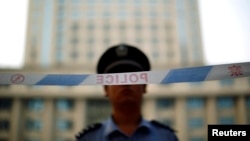 Seorang polisi berjaga di depan gedung pengadilan di Jinan, provinsi Shandong, 24 Agustus 2015 (Foto: dok).