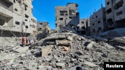 Palestinians gather at the site of Israeli strikes on houses and residential buildings in Beit Lahiya, Gaza Strip, on Oct. 20, 2024.