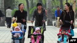 妇女推着婴儿车在北京公园里散步（2011年4月5日）