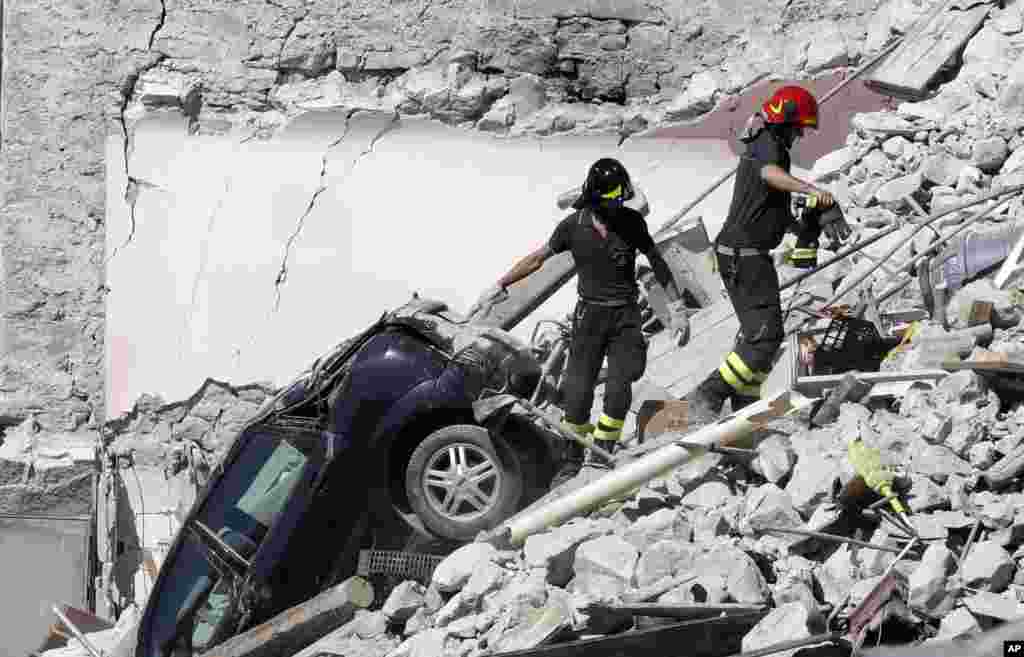 Rescuers make their way through destroyed houses following Wednesday's earthquake in Pescara Del Tronto, Italy.