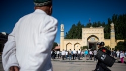Tampak para pria muslim tiba di Masjid Id Kah di kota Kashgar, Xinjiang, untuk melaksanakan sholat Idul Fitri pada 26 Juni 2017. (Foto: AFP/Johannes Eisele)