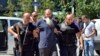 FILE - Kosovo police escort a man suspected of having fought with Islamist insurgents in Syria and Iraq, in Pristina, Aug. 12, 2014. Kosovo has taken a proactive approach to reintegrating citizens who joined the IS.