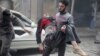 A resident carries an injured man through a site damaged from what activists said was an airstrike by forces loyal to Syria's President Bashar al-Assad on the main field hospital in the town of Douma, Syria, Oct. 29, 2015.