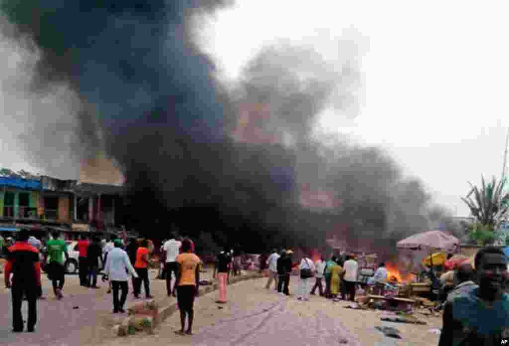 Hayaki ya turnuke samaniya, bayan fashewar tagwayen boma-bomai a tashar motar Bus da aka fi sani da “taminos” a birnin Jos, dake Jihar Filato a Najeriya, Talata Mayu 20, 2014.