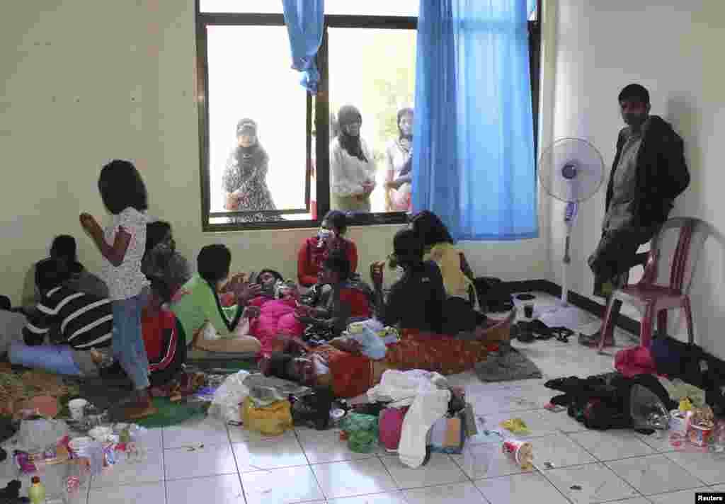 Suspected asylum seekers who were on a boat that capsized July 23, 2013, after hitting a reef, sit at a temporary shelter near Jayanti beach, West Java, Indonesia, July 24, 2013. 