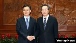 한국 측 6자회담 수석대표인 황준국 외교부 한반도평화교섭본부장이 지난해 4월 베이징에서 중국 측 6자회담 수석대표인 우다웨이 한반도사무특별대표과 만나 악수하고 있다. (자료사진)